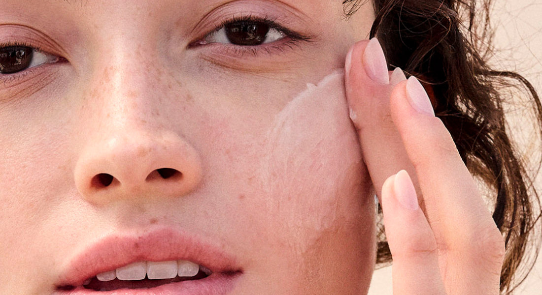 Close-up of a person applying cream to their face