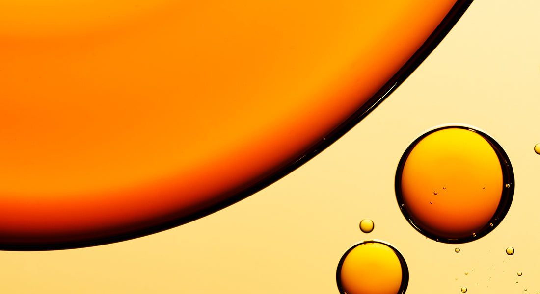Close-up of droplets of skincare products on orange background