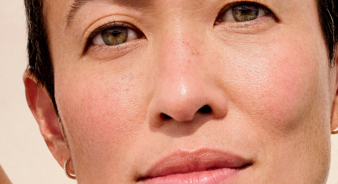 Close-up of a person's face with a neutral expression on a beige background