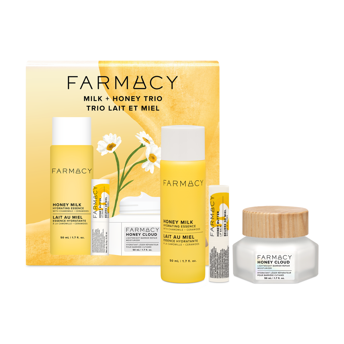 Farmacy Milk + Honey Trio skincare set including a 50mL Honey Milk Essence bottle, 50mL Honey Cloud moisturizer, Honey Butter Lip Balm and matching box on a white background.